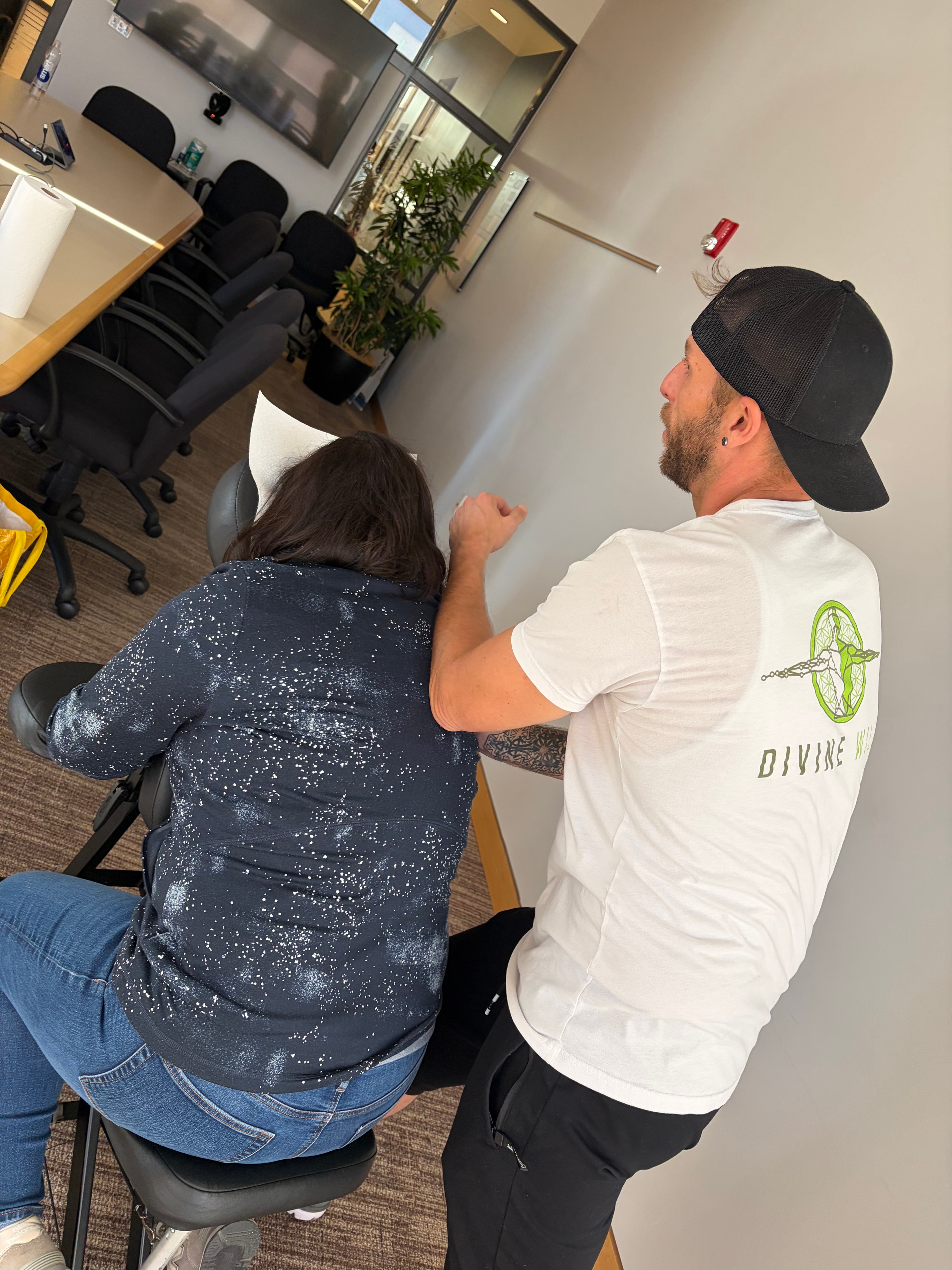 Divine Will Healing therapist performing chair massage at an event